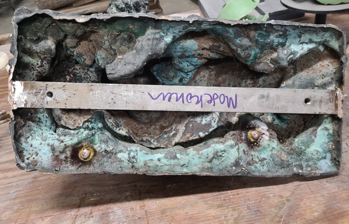 Rustfri stålskinne svejset i bunden af ældre skulptur